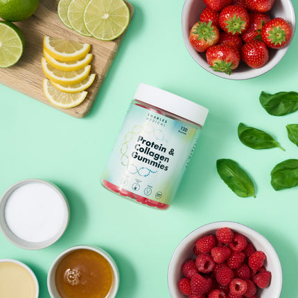 Jar of vegan sugar-free collagen protein 120 gummies surrounded by fresh fruits and ingredients on a green background.