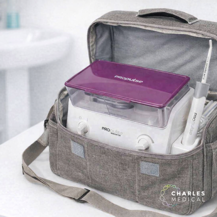 Gray medical bag with ear irrigation machine equipment on a white surface, branded 'Charles Medical'.