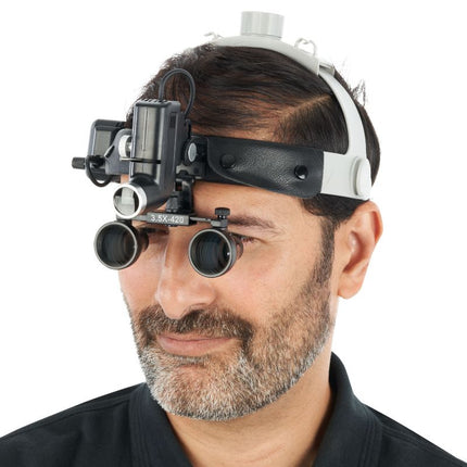 Magnification headset worn during medical procedure with case visible nearby