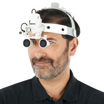 Magnification headset worn during medical procedure with case visible nearby