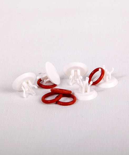 White plastic clips with red rubber bands on a light gray background
