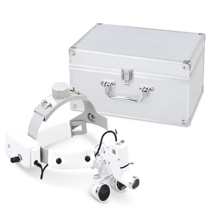 Wireless 3.5X headband loupes in black with protective aluminium storage case

White 3.5X magnifying headset shown with included case for surgical or dental use

Optical loupes inside lightweight aluminium case for secure transport

Magnification headset worn during medical procedure with case visible nearby

Jeweller using 3.5X headband loupes with case shown for storage